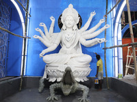 An artisan paints near idols of the Hindu goddess Durga under the Hooghly River, visible from a model of a metro compartment ahead of the Du...