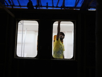 An artisan works inside a model of a metro compartment in a ''pandal'' or temporary platform ahead of the Durga Puja festival in India on Se...