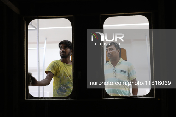 Artisans work inside a model of a metro compartment in a ''pandal'' or a temporary platform ahead of the Durga Puja festival in India on Sep...