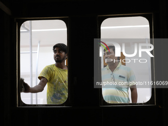 Artisans work inside a model of a metro compartment in a ''pandal'' or a temporary platform ahead of the Durga Puja festival in India on Sep...