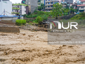 The flooding of the Nakhu River damages the road and riverbank during heavy rainfall in Lalitpur, Nepal, on September 28, 2024. Due to road...