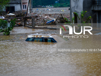 Vehicles are submerged in the flooding of the Nakhu River in Lalitpur, Nepal, on September 28, 2024. (