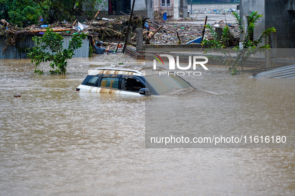 Vehicles are submerged in the flooding of the Nakhu River in Lalitpur, Nepal, on September 28, 2024. 