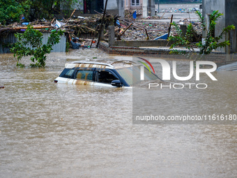 Vehicles are submerged in the flooding of the Nakhu River in Lalitpur, Nepal, on September 28, 2024. (