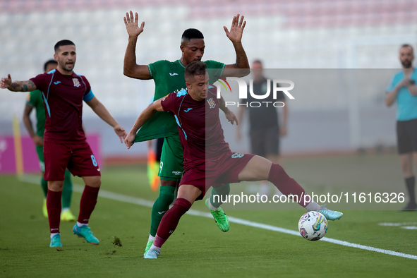 In Ta' Qali, Malta, on September 27, 2024, Thiago Espindola de Paula of Gzira United is challenged from the back by Kemar Reid of Floriana d...