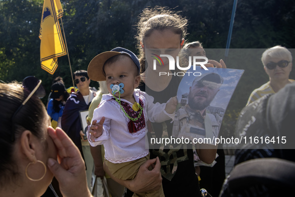 Ukrainians hold portraits of a fallen Ukrainian soldier during a march marking the upcoming Defenders of Ukraine Day in Kyiv, Ukraine, on Se...