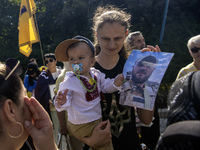 Ukrainians hold portraits of a fallen Ukrainian soldier during a march marking the upcoming Defenders of Ukraine Day in Kyiv, Ukraine, on Se...