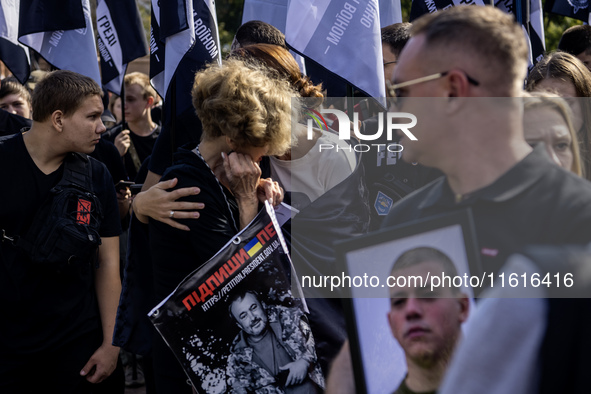 Ukrainians hold portraits of a fallen Ukrainian soldier during a march marking the upcoming Defenders of Ukraine Day in Kyiv, Ukraine, on Se...