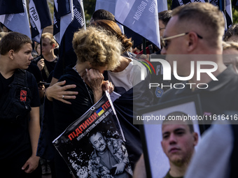 Ukrainians hold portraits of a fallen Ukrainian soldier during a march marking the upcoming Defenders of Ukraine Day in Kyiv, Ukraine, on Se...