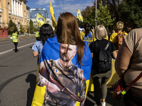 People carry flags with portraits of a fallen Ukrainian soldier during a march marking the upcoming Defenders of Ukraine Day in Kyiv, Ukrain...