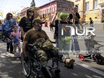 Ukrainians attend a march marking the upcoming Defenders of Ukraine Day in Kyiv, Ukraine, on September 28, 2024 (