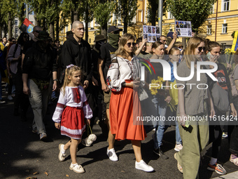 Ukrainians attend a march marking the upcoming Defenders of Ukraine Day in Kyiv, Ukraine, on September 28, 2024 (