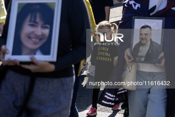 Ukrainians hold portraits of a fallen Ukrainian soldier during a march marking the upcoming Defenders of Ukraine Day in Kyiv, Ukraine, on Se...