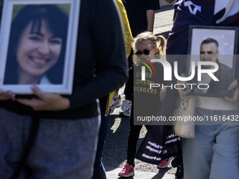 Ukrainians hold portraits of a fallen Ukrainian soldier during a march marking the upcoming Defenders of Ukraine Day in Kyiv, Ukraine, on Se...