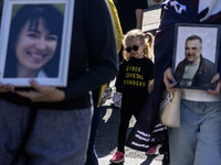 Ukrainians hold portraits of a fallen Ukrainian soldier during a march marking the upcoming Defenders of Ukraine Day in Kyiv, Ukraine, on Se...