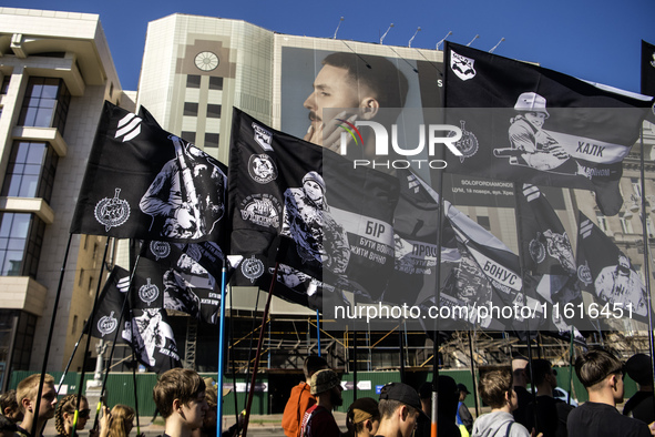 People carry flags with portraits of a fallen Ukrainian soldier during a march marking the upcoming Defenders of Ukraine Day in Kyiv, Ukrain...