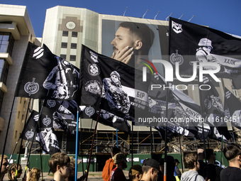 People carry flags with portraits of a fallen Ukrainian soldier during a march marking the upcoming Defenders of Ukraine Day in Kyiv, Ukrain...