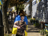 People carry flags with portraits of a fallen Ukrainian soldier during a march marking the upcoming Defenders of Ukraine Day in Kyiv, Ukrain...