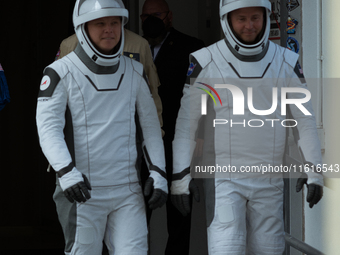 Astronauts Nick Hague and Alexander Gorbunov emerge from the astronaut clean room to begin their journey to the launch pad (