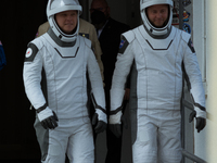 Astronauts Nick Hague and Alexander Gorbunov emerge from the astronaut clean room to begin their journey to the launch pad (