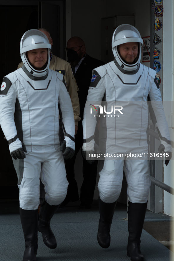 Astronauts Nick Hague and Alexander Gorbunov emerge from the astronaut clean room to begin their journey to the launch pad 