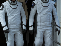 Astronauts Nick Hague and Alexander Gorbunov emerge from the astronaut clean room to begin their journey to the launch pad (