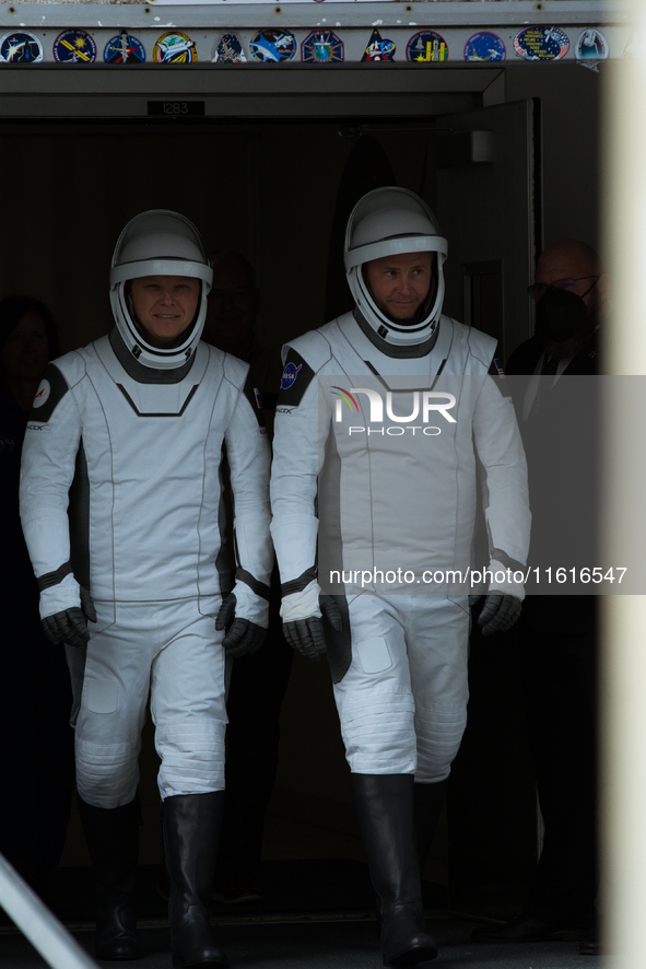 Astronauts Nick Hague and Alexander Gorbunov emerge from the astronaut clean room to begin their journey to the launch pad 