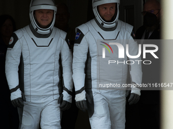 Astronauts Nick Hague and Alexander Gorbunov emerge from the astronaut clean room to begin their journey to the launch pad (