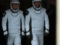 Astronauts Nick Hague and Alexander Gorbunov emerge from the astronaut clean room to begin their journey to the launch pad (