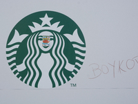 The writing of ''boycott'' is seen next to the logo of Starbucks as about a hundred pro-Palestinian protesters gather in Bonn and protest ag...