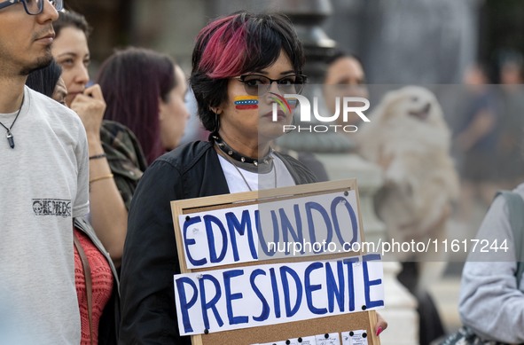 A woman with a Venezuelan flag drawn on her face and carrying a banner with political slogans gathers during a demonstration at Restauradore...