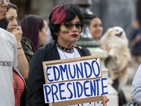 A woman with a Venezuelan flag drawn on her face and carrying a banner with political slogans gathers during a demonstration at Restauradore...