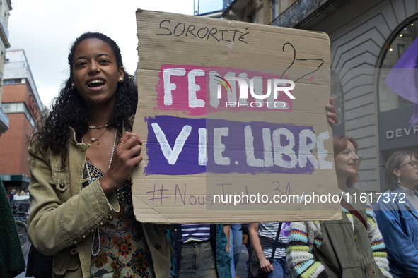 A woman holds a cardboard sign reading 'Women, life, free'. For International Safe Abortion Day, hundreds of women and men take to the stree...