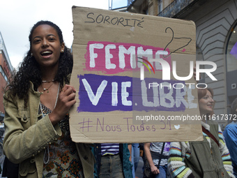 A woman holds a cardboard sign reading 'Women, life, free'. For International Safe Abortion Day, hundreds of women and men take to the stree...