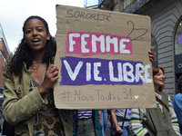 A woman holds a cardboard sign reading 'Women, life, free'. For International Safe Abortion Day, hundreds of women and men take to the stree...