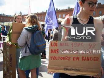 A young woman holds a cardboard sign reading '1975 Veil law, 48 years after, abortion is still in danger'. In Toulouse, France, on September...