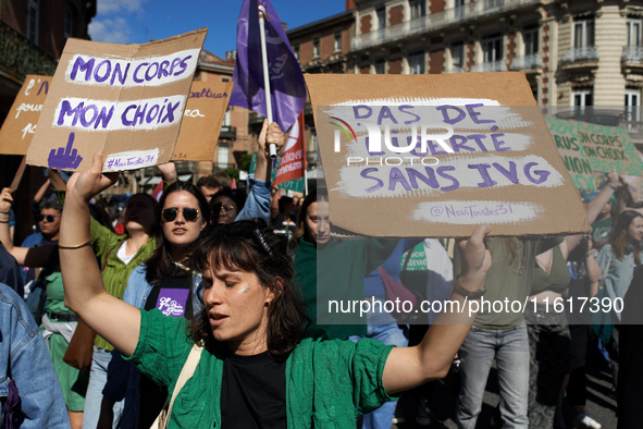 A woman holds cardboard signs reading 'My body, my choice' and 'No freedom without abortion'. For International Safe Abortion Day, hundreds...