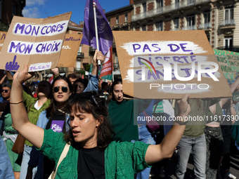 A woman holds cardboard signs reading 'My body, my choice' and 'No freedom without abortion'. For International Safe Abortion Day, hundreds...