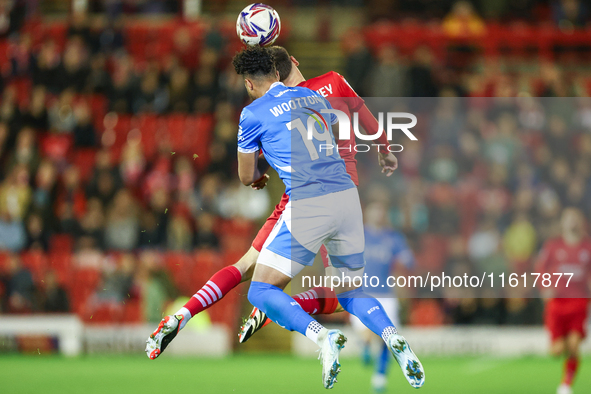 #19, Kyle Wootton of Stockport, and #6, Mael de Gevigney of Barnsley, battle to head the ball during the Sky Bet League 1 match between Barn...