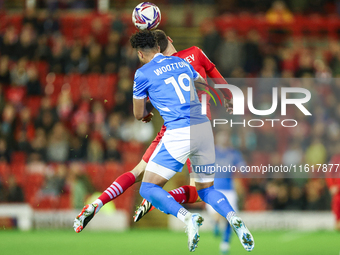 #19, Kyle Wootton of Stockport, and #6, Mael de Gevigney of Barnsley, battle to head the ball during the Sky Bet League 1 match between Barn...