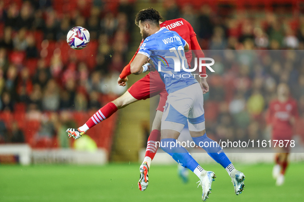 #19, Kyle Wootton of Stockport, and #6, Mael de Gevigney of Barnsley, battle to head the ball during the Sky Bet League 1 match between Barn...