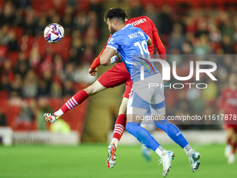 #19, Kyle Wootton of Stockport, and #6, Mael de Gevigney of Barnsley, battle to head the ball during the Sky Bet League 1 match between Barn...