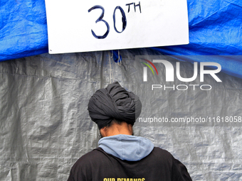 An organizer adjusts a tent and sets up for a protest at an international students' encampment in Brampton, Canada, on September 28, 2024. T...