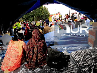 Two women sit in a tent and listen to speakers during a protest rally at an international students' encampment in Brampton, Canada, on Septe...