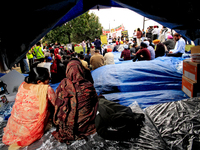 Two women sit in a tent and listen to speakers during a protest rally at an international students' encampment in Brampton, Canada, on Septe...