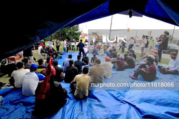 Participants sit and listen to speakers during a protest rally at an international students' encampment in Brampton, Canada, on September 28...