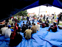 Participants sit and listen to speakers during a protest rally at an international students' encampment in Brampton, Canada, on September 28...