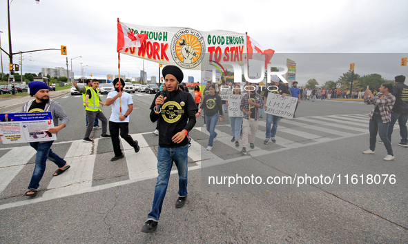 Participants walk across Queen Street during a protest rally at an international students' encampment in Brampton, Canada, on September 28,...