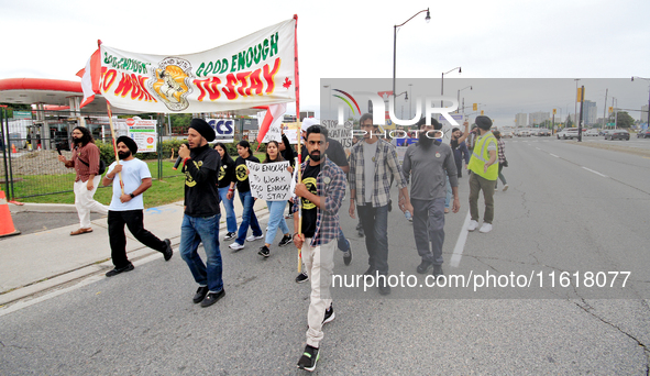 Participants walk along Queen Street during a protest rally at an international students' encampment in Brampton, Canada, on September 28, 2...