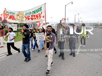 Participants walk along Queen Street during a protest rally at an international students' encampment in Brampton, Canada, on September 28, 2...